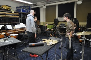 Composer Jonathan Pfeffer (grey hoodie) guides the members of Third Coast Percussion through a series of musical ideas. Ensemble members from left to right: Robert Dillon, David Skidmore, Peter Martin (kneeling), and Sean Connors. 