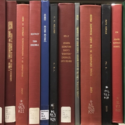 The spines of 10 cloth-bound, archival copies of dissertations by Eastman graduates.