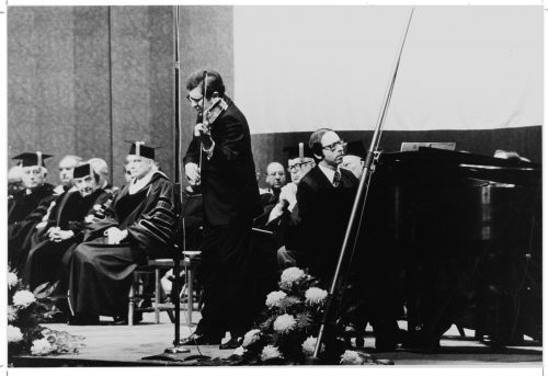 Professors Zvi Zeitlin and Barry Snyder performing on-stage in the Eastman Theater. The Honorable Golda Meir is seated at left, with U of R Chancellor W. Allen Wallis at her left.