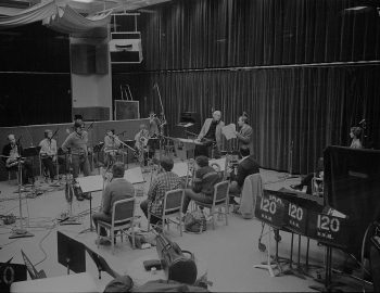 Rayburn Wright, Eastman Jazz Ensemble director, conducting members of the Eastman Jazz Ensemble in Room 120 (today known as the Ray Wright Room) on February 27th, 1983 during the recording session for the French-Canadian film Bonheur d’occasion. Louis Ouzer Archive