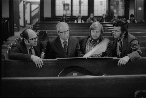 R1308-30 During a rehearsal in Lake Avenue Baptist Church, Eastman School composers Samuel Adler, Wayne Barlow, and Joseph Schwantner peruse the score of the Concerto for Organ and Orchestra, joined (at right) by local music critic Ted Price.