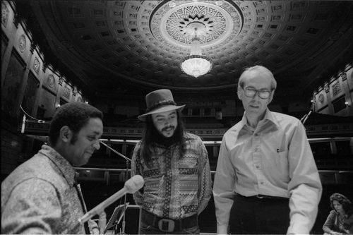 Oliver Nelson, Chuck Mangione, and Ray Wright confer on the podium in the Eastman Theater preparatory to the Eastman Jazz Ensemble and Eastman Studio Orchestra joint concert of March 3rd, 1972