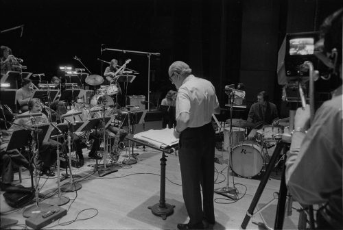 Director Jack End, guest percussion soloist John Beck, and the members of the Eastman Jazz Ensemble on-stage in the Eastman Theater before their premiere performance of the Piece for Percussion and Jazz Ensemble, April 14th and 15th, 1972. Photo by Louis Ouzer.