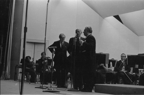 Eastman School Director Walter Hendl introducing guest composer-conductor Aram Khachaturian, and Mr. Khachaturian’s assistant, Mr. Joseph Zarovich, translating the composer’s comments for the audience.