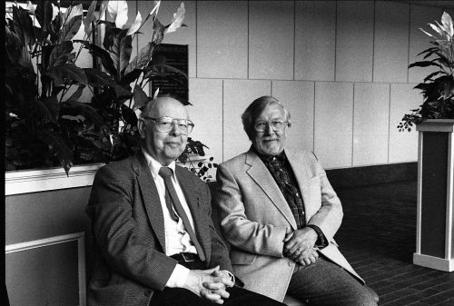 Photographer Louis Ouzer and composer Warren Benson posing in the atrium of Eastman Place (today, Sproull Atrium in Miller Center) at the reception honoring Ruth Watanabe, May, 1996. Presumably, Mrs. Helen Ouzer obliged with taking this photograph.