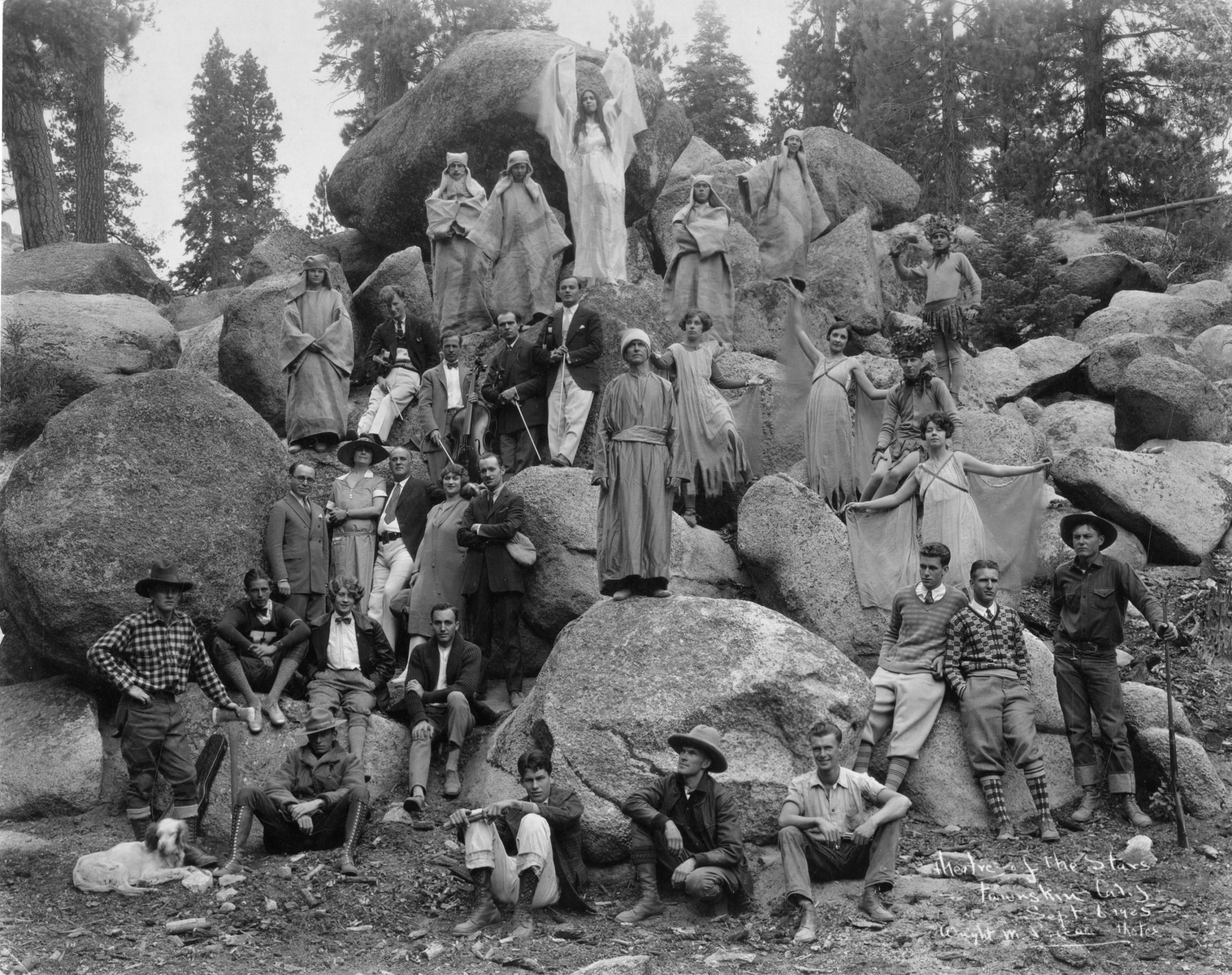Cast of The March of Man, posing on a wall of boulders.