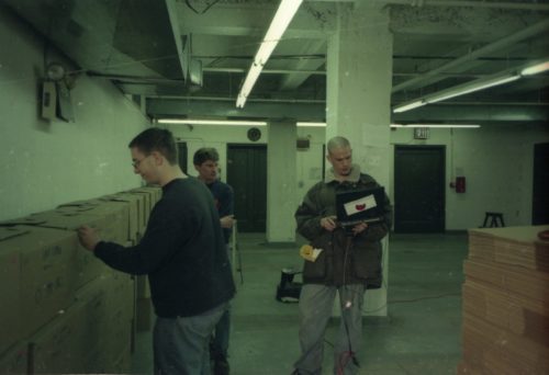 image 17 team members Brodsky, Coppen and Quinn are seen among the lines of shipping crates