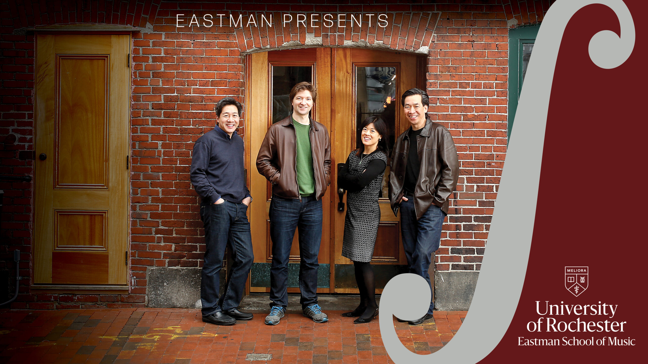 A Photo of the Ying Quartet standing in front of the. double doors of a. brick building. The design flourish for Eastman Presents' Eastman-Ranlet Series is on the right side of the frame
