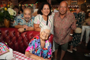 Alumna Gloria Mikialian '45E with her three living children-Gary, Mara. and Greg Mikialian-at her 100th birthday party.