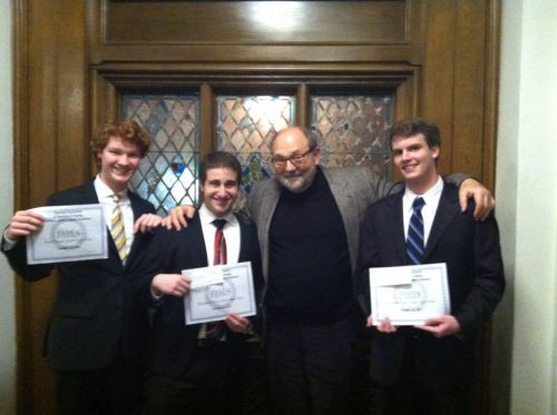 Professor Swensen and three students in suits holding certificates.