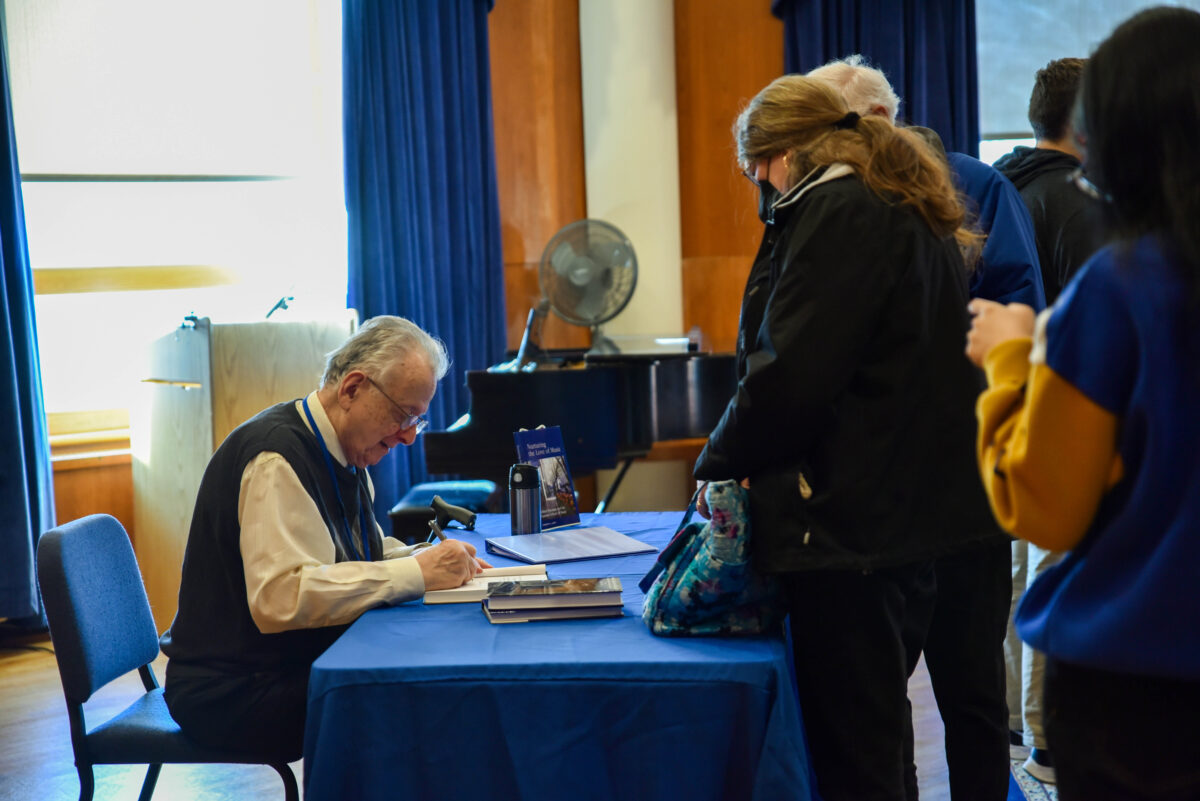 Lenti signs copies of ‘Nurturing the Love of Music,’ the third book in his history of Eastman