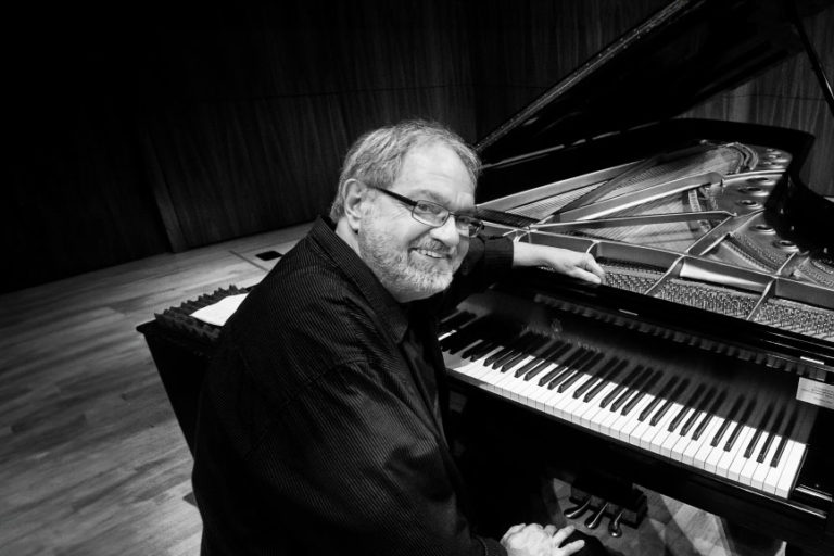 Harold Danko sitting at piano on stage
