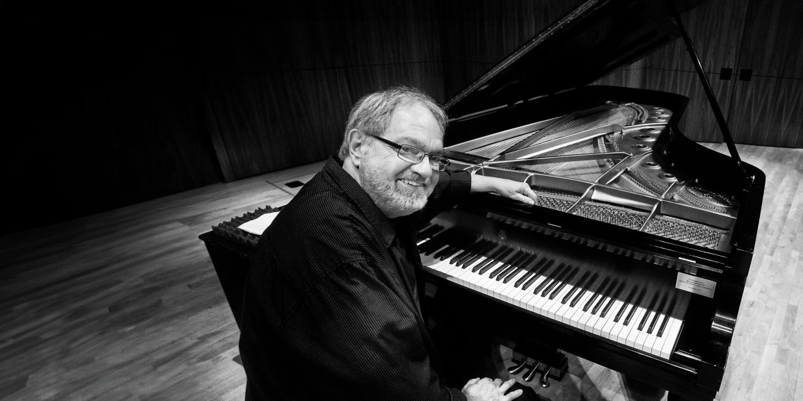 Harold Danko sitting at piano on stage
